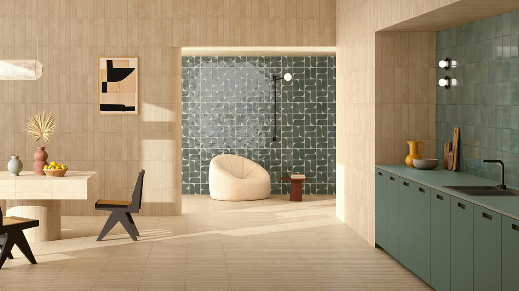 In the open-plan living room and kitchen, Del Conca tiles combine neutral tones and deep greens, enhancing brightness and adding a sophisticated graphic touch to walls and backdrops.